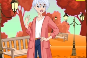 Persona de cabello blanco y corto sonriendo, con un abrigo rosa y pantalones azules, en un parque otoñal con árboles rojos y bancos de madera
