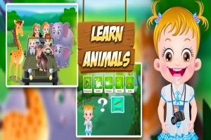 Niña sonriente con ropa azul al lado de un póster que muestra un safari con animales como jirafa y elefante y la frase Learn Animals