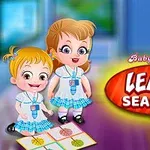 Dos niñas con uniformes escolares están sonriendo en un aula mientras interactúan con un juego de mesa que muestra diferentes estaciones del año