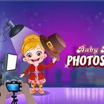 Niña rubia con vestido rojo y sombrero en mano en un estudio de fotografía, con luces y cámara, sobre un fondo morado brillante