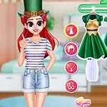 Persona con sombrero verde de pie junto a un perchero con vestidos verdes en una habitación