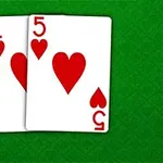 Dos cartas de póker, un as y un cinco de corazones, sobre un fondo verde