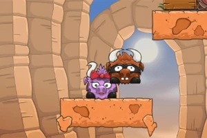 Dos búfalos caricaturizados, uno morado y otro marrón, con cuernos, están en una plataforma de roca en un paisaje con paredes de cañón y el cielo de fondo