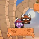 Dos búfalos caricaturizados, uno morado y otro marrón, con cuernos, están en una plataforma de roca en un paisaje con paredes de cañón y el cielo de fondo