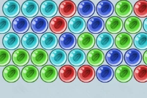 Fila de esferas de colores azul, rojo y verde organizadas en un patrón repetitivo sobre un fondo claro