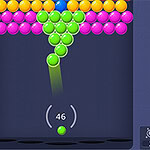 Pantalla de un juego con esferas de colores que se agrupan mientras se dispara una esfera verde desde la parte inferior