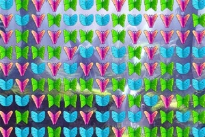 Mariposas de colores brillantes, verde, azul y rosa, organizadas en un patrón repetitivo sobre un fondo natural