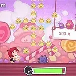 Personaje en un mundo de dibujos animados con temática de dulces, rodeado de caramelos y figuras triangulares amarillas, y un letrero que indica 500 M con dos pájaros sentados