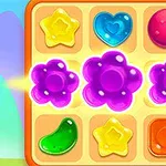 Tablero de juego con fichas de formas y colores variados, incluyendo flores moradas brillantes, corazones azules, y estrellas amarillas