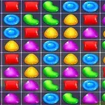 Caramelos de colores en una cuadrícula, incluyendo formas como frijoles verdes, gotas azules, y triángulos amarillos