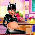 Mujer embarazada con traje negro de gato sentada en una cocina colorida