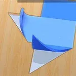 Figura de papel doblado en tonos azul, blanco y naranja sobre una superficie de madera