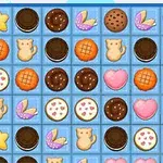 Galletas de diferentes formas y colores (estrellas, corazones, gatos, círculos) dispuestas en un tablero de fondo azul