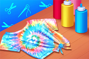 Camiseta con diseño tie-dye colorido sobre una mesa de madera, acompañada de botellas de tinte de colores rojo, amarillo y azul, con fondo azul decorado con íconos de tijeras y aguja