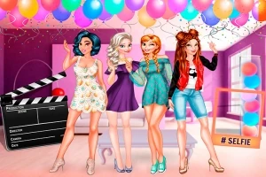 Cuatro chicas sonrientes posan en una fiesta decorada con globos y luces de colores, junto a una claqueta de cine y un cartel que dice #SELFIE