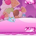 Escenario colorido con fondo de helados y dulces, y un personaje azul con aspecto alegre deslizándose en una superficie rosa