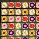 Un tablero con filas de flores de diferentes colores y tipos en celdas cuadradas