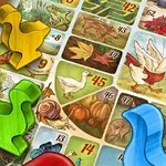 Fichas de colores sobre un tablero decorado con ilustraciones de animales y plantas numeradas