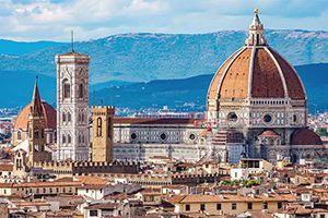 Vista panorámica de Florencia con la catedral de Santa María del Fiore y su gran cúpula, junto al campanario, con montañas al fondo