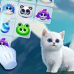 Un gatito blanco con ojos azules junto a un tablero de juego con adorables criaturas de colores y una mano señalando una de ellas