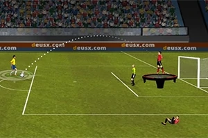 Jugador en campo de fútbol realizando un tiro mientras un árbitro y jugadores observan, con un portero sobre un trampolín frente a la portería