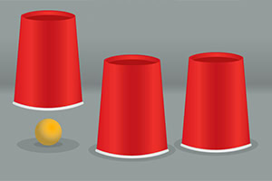 Tres vasos rojos invertidos en fila con una pequeña pelota amarilla visible junto a uno de ellos