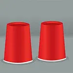 Tres vasos rojos invertidos en fila con una pequeña pelota amarilla visible junto a uno de ellos