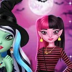 Dos chicas disfrazadas en un entorno de Halloween con una luna llena y murciélagos al fondo