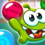 Personaje verde con grandes ojos y dientes afilados sostiene una esfera de colores brillantes en un entorno de burbujas coloridas