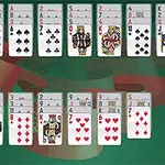 Baraja de cartas de juego organizadas en filas con un fondo verde, destacando un as de espadas a la derecha