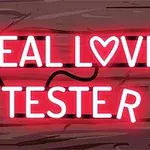 Letrero de neón rojo que dice REAL LOVE TESTER con un corazón en lugar de la O sobre un fondo de madera