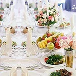 Mesa elegante decorada con arreglos florales y platos de frutas en un banquete