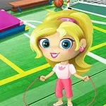 Niña de cabello rubio y ojos grandes saltando la cuerda en una cancha con áreas deportivas marcadas