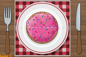 Un galleta con glaseado rosa y chispas de colores sobre un plato blanco con un patrón de mantel rojo y blanco, acompañada de un tenedor y un cuchillo