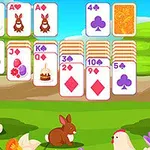 Cartas de juego con ilustraciones de conejos y símbolos, en un paisaje primaveral con flores, un conejo y una gallina