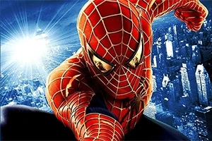 Persona con traje rojo y azul con patrón de telaraña columpiándose sobre una ciudad iluminada