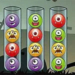 Cuatro tubos transparentes contienen bolas coloridas con caras de monstruos de un solo ojo