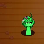 Una criatura verde con cabello de flores emerge de un agujero en un suelo marrón