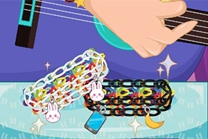 Mano tocando guitarra con pulsera de cadenas coloridas adornadas con dijes de conejo, teléfono y luna