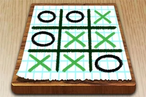 Tablero de papel cuadriculado con un juego de tres en línea usando círculos negros y equis verdes sobre una superficie de madera