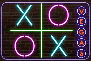 Neón de colores brillantes formando un tablero de tres en raya con las letras XO y VEGAS en un fondo de ladrillos