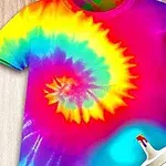 Camiseta con diseño espiral de colores brillantes en estilo psicodélico sobre fondo de madera clara, acompañada de una botella de pintura al frente