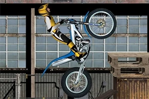 Motociclista realizando acrobacias en una motocicleta frente a un fondo industrial