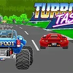 Camión monstruo azul y auto deportivo rojo en una carretera con un letrero que dice Turbotastic