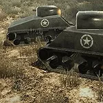 Dos tanques verdes con una estrella blanca avanzando sobre un terreno arenoso con vegetación escasa