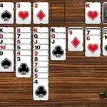 Cartas de naipes organizadas en un juego sobre una mesa de madera con una estrella de sheriff en la esquina