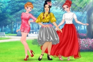 Tres mujeres jóvenes con vestidos coloridos posando en un parque verde y soleado