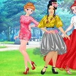Tres mujeres jóvenes con vestidos coloridos posando en un parque verde y soleado