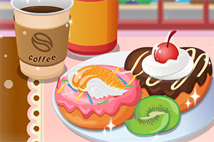 Donas decoradas con crema y frutas junto a una taza de café sobre una mesa